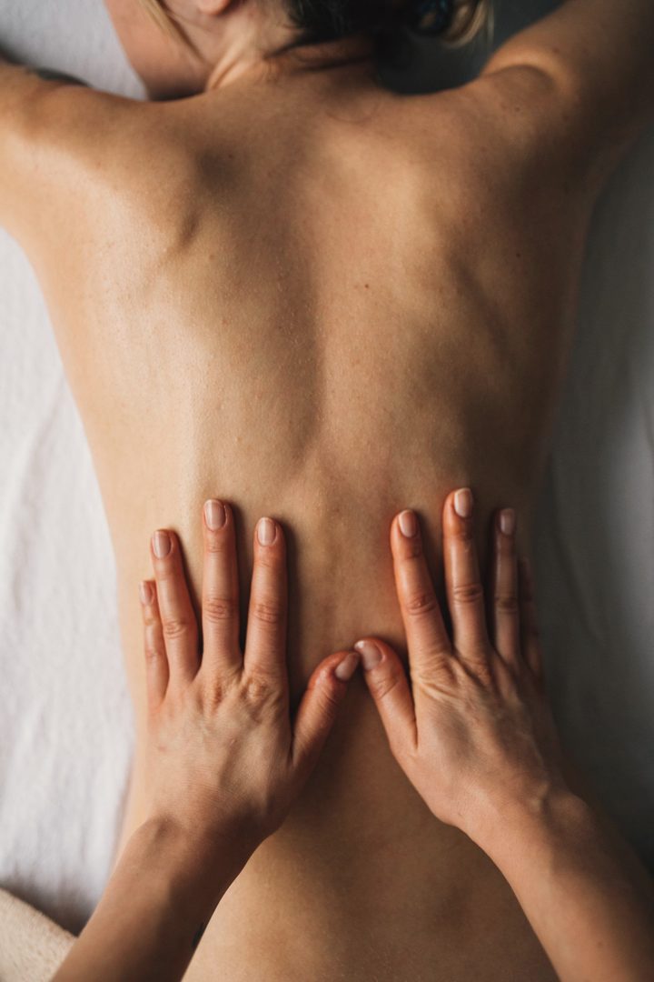 A massage therapist's hands working across a back